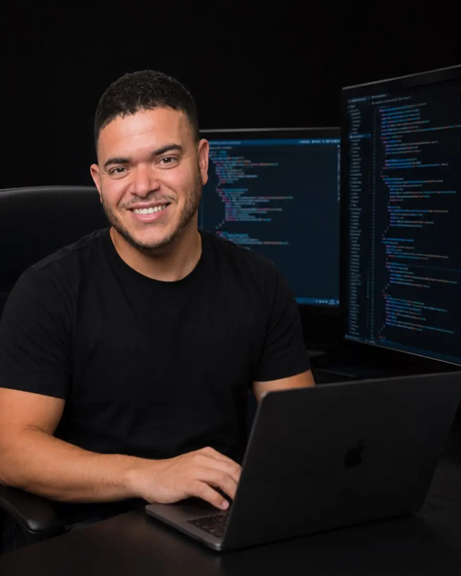 Abel, diseñador web, programando entre dos pantallas de código